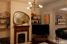 a living room filled with furniture and a flat screen tv mounted on a wall next to a fire place