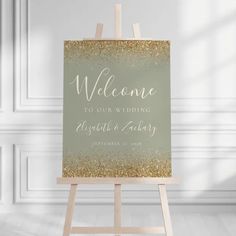 an easel with a sign that says welcome to our wedding and gold glitter on it