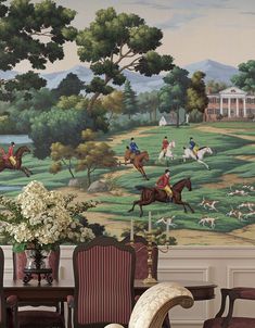 a wall mural with horses and people on it in a dining room or living room