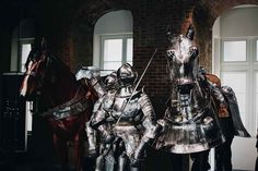 two knights in full armor standing next to each other near a horse and another man