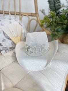 a white brimmed hat sitting on top of a bed