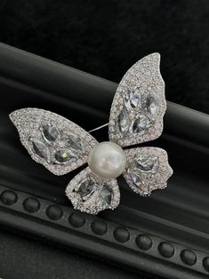 Embrace elegance with our Butterfly Brooch, featuring a radiant 8-9mm freshwater pearl nestled among sparkling cubic zirconia. Available in gold and silver finishes, this exquisite piece adds a touch of sophistication to any outfit. A perfect gift to symbolize transformation and beauty Material: Gold plated on brass, cubic zirconia, and freshwater pearls Pearl Size: 8-9mm Note: Our jewelry is handmade. Naturally formed shapes of freshwater baroque pearls may vary. The actual product may be sligh White Butterfly Brooches For Gifts, Handmade Elegant Butterfly Brooches, Elegant Silver Butterfly Brooch, Elegant Collectible Butterfly Brooches, Luxury Vintage Brooch With Pearl Pendant, Large Pearl Earrings, Mother Of Pearl Earrings, Purple Pearl, Freshwater Pearl Bracelet