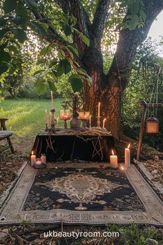 a table with candles on it under a tree