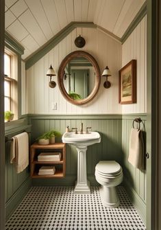 a white toilet sitting next to a sink in a bathroom under a round mirror on the wall