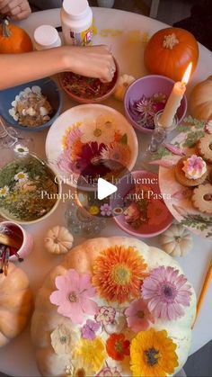 a table topped with lots of plates and bowls filled with different types of flowers on top of it