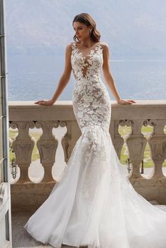 a woman in a wedding dress standing on a balcony