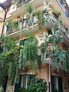 an apartment building with plants growing on the balconies