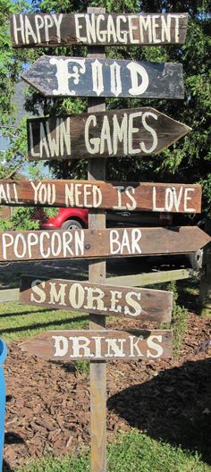 a wooden sign that says happy engagement, lawn games, all you need is love popcorn and smores drinks