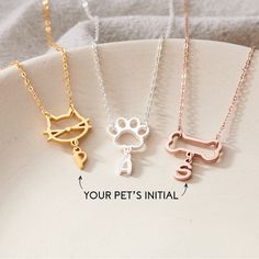 three different necklaces with the words your pet's initial on them