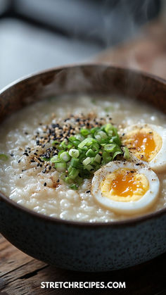 a bowl of oatmeal with eggs, chives and sesame seeds on top