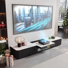 a living room with a large television mounted to the wall next to a christmas tree