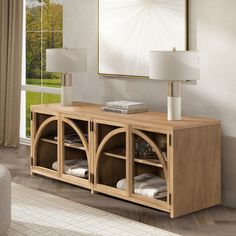 a living room with a large window and a wooden cabinet in front of the wall