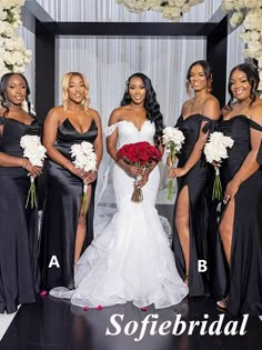 a group of women standing next to each other in front of a white flower arch