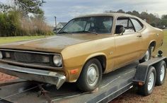 an old car is being towed on a flatbed trailer