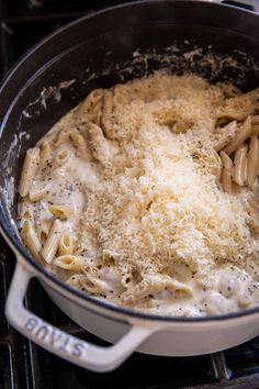 a pot filled with pasta and cheese on top of an oven