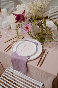 the table is set with flowers and place settings