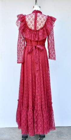 "Vintage Lace Maxi Dress in Vibrant Cranberry Color! Perfect for a vintage wedding !! This is STUNNING !! *Ruffled *Floral Lace *Lace is see through on neck and sleeves *Long Sleeves - Please note that the right sleeve was cut short - do not know why as the other one is original length. This is how we found it and sold As Is. Pretty simple job for a seamstress to shorten the other one to make them the same length. Priced accordingly! *Zip up on back *Floor Length *Lined - Lace even on back part 1970s Style Spring Wedding Dress, 1970s Style Wedding Dresses For Spring, Retro Maxi Dress For Wedding, Vintage Floor-length Dress For Vintage Events, Floor-length Vintage Dress For Vintage Events, Vintage Maxi Wedding Dress, Vintage Wedding Maxi Dress, Retro Floor-length Maxi Dress For Wedding, Vintage Floor-length Maxi Dress For Vintage Events