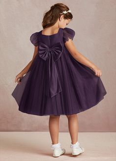 Kalio is our adorable tulle and matte satin flower girl dress. She features a square neckline that is framed with charming short flutter sleeves. She has an empire waist that offers comfort and ease of movement. The flowy A-line skirt adds whimsy while the removable bow gives this dress versatility. This dress is not only perfect for a flower girl at a wedding but also versatile enough for other special occasions. Plum Flower Girl Dresses, Satin Flower Girl Dress, Plum Flowers, Flower Girl Dresses Tulle, Satin Flowers, Dress Flower, Matte Satin, Flower Girl Dress, Flutter Sleeves