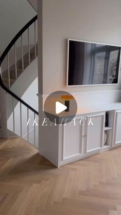 a living room with white furniture and a flat screen tv mounted to the side of a wall