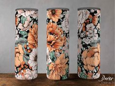 three floral vases sitting on top of a wooden table