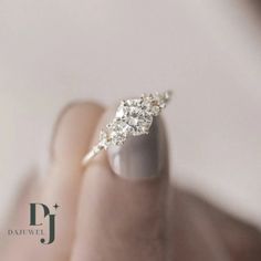 a woman's hand with a diamond ring on top of her finger, showing the middle