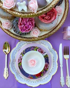 a table set with plates, silverware and flowers