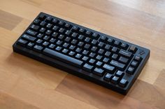 a black keyboard sitting on top of a wooden floor