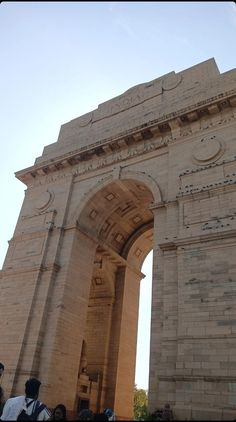 people are standing in front of an arch