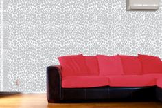 a red couch sitting in front of a wall mounted air conditioner