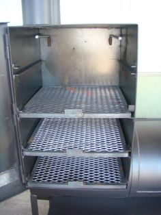 the inside of an industrial refrigerator with metal shelves and grates on it's sides