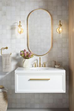 a bathroom with a sink, mirror and lights on the wall next to the toilet