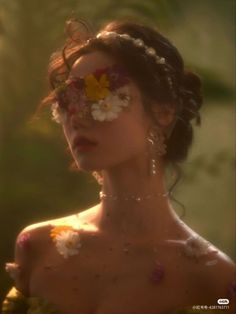 a woman with flowers painted on her face and chest, in front of the sun