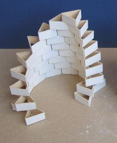 a sculpture made out of white cardboard sitting on top of a table