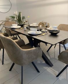 a dining room table with chairs and plates on it