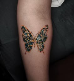 a woman's leg with a butterfly tattoo on it