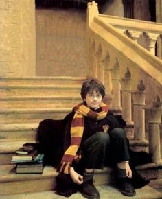 a painting of a boy sitting on the steps with books in his lap and scarf around his neck