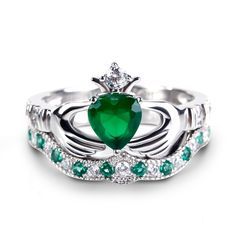 Celebrating love, beauty and Irish culture, this claddagh ring set will capture your heart at first sight. Crafted in sleek sterling silver, the ring features an emerald green heart center stone set on a high polished shank. The traditional claddagh ring is a meaningful token of loyalty, friendship and love. The hands represent friendship, the heart represents love and the crown represents loyalty.With the beautiful coordinating band, the ring is a dazzling look of love.Carat Weight: 1.4 ctStone Fine Jewelry Green Heart Ring For May Birthstone, Heart-shaped Emerald Rings For Wedding, Green Heart Ring For May Birthstone, Fine Jewelry Style, Green Heart Ring For May Birthstone, Classic Green Heart Cut Rings, Heart Shaped Green Emerald Ring For May Birthstone, Green Fine Jewelry Heart Ring For Wedding, Heart-shaped Green Emerald Ring For May Birthstone, Elegant Heart-shaped Green Emerald Ring