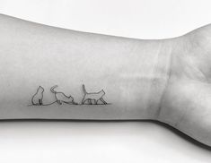 a cat and dog tattoo on the wrist