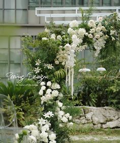 an outdoor wedding ceremony with white flowers and greenery