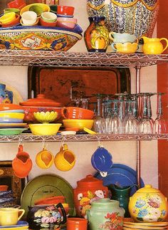 the shelves are filled with colorful dishes and cups, plates and vases on them