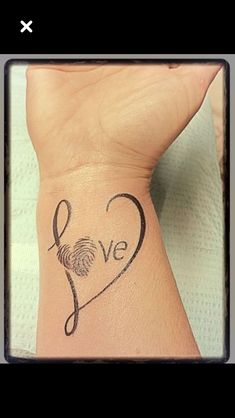 a woman's arm with a tattoo on it that says love and an image of a fingerprint in the shape of a heart