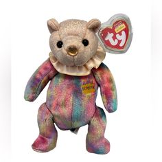 a small teddy bear with a tag on it's neck and tie dye pattern