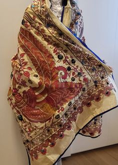 "This original scarf in vibrant color will bring a unique touch to your entire look. Kantha is a centuries-old tradition of stitching patchwork cloth from rags, which evolved from the thrift of rural women in the Bengali region of the sub-continent  \"Kantha\" refers to both the style of running stitch, as well as the finished cloth. Tussar Silk , also often referred to as 'Wild Silk, Tassar Silk, or Tusar Silk is an exquisite thread obtained from a wide winged moth that is yellowish-brown in colour. Dimensions:  L : 230 CM (approx) W: 90 CM (approx) Pattern:floral and peacock  Fabric: Silk Base Color: Beige  Usage: Maintenance: Due to the delicacy of the product, only dry cleaning is recommended. Note: As each piece is original and hand crafted and embroidered, there might be some small b Farm Fashion, Peacock Fabric, Rural Women, Embroidered Scarf, Peacock Design, Running Stitch, Shawls And Wraps, Hand Embroidered, Shawl