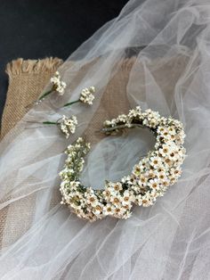 white flowers are arranged on a piece of fabric and burlocked with tulle