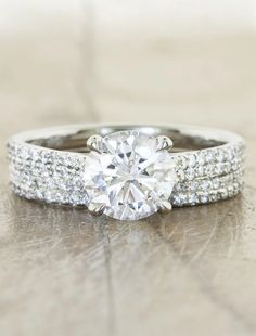 a diamond engagement ring sitting on top of a wooden table