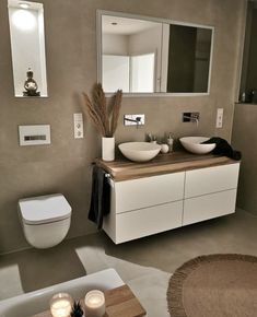 a modern bathroom with two sinks and a toilet in it's center area, along with a rug on the floor