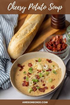 a bowl of cheesy potato soup with bacon, green onions and bread in the background