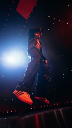 a man standing on top of a stage with his arms in the air while holding a microphone