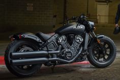 a man standing next to a black motorcycle