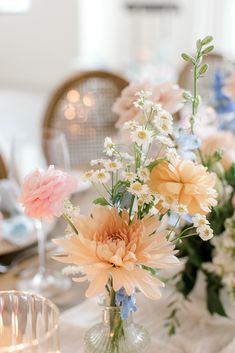 there are many flowers in the vases on the dining room table set for dinner